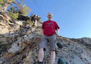 Old Hiking Dude standing on rocky terrain below Cardiff Peak